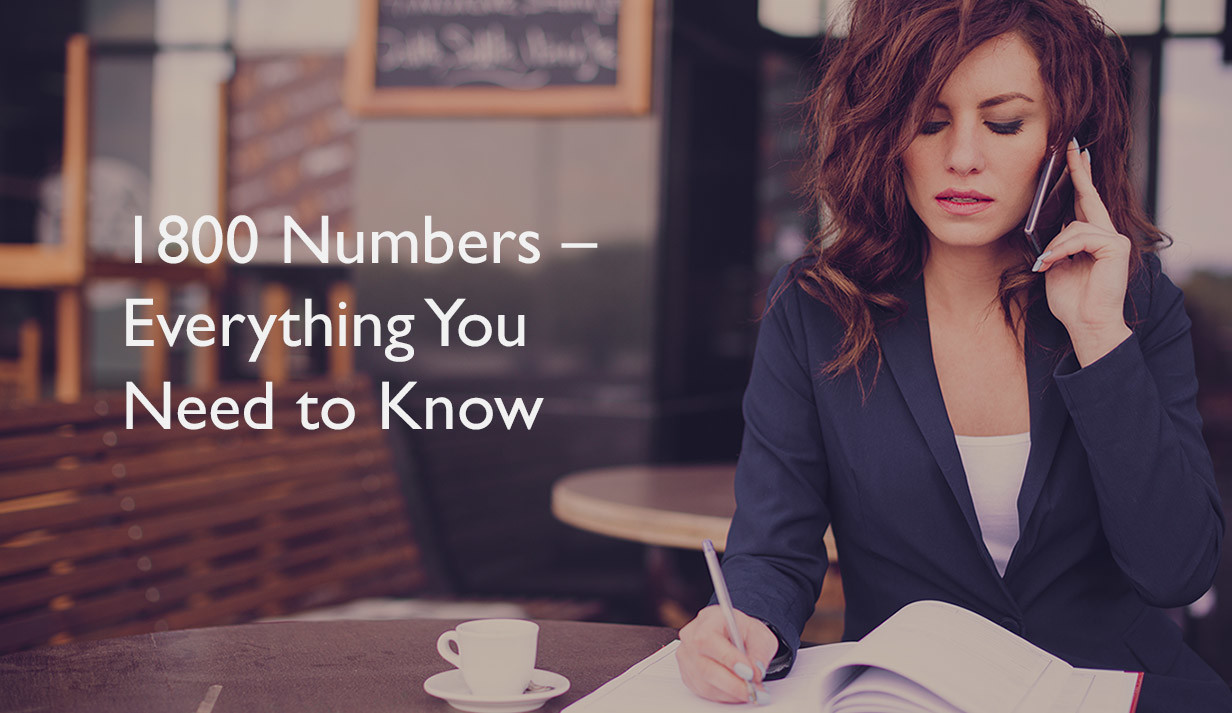 Young business woman sitting at the table, writing in a notebook and talking on the phone 1800-numbers-everything-you-need-to-know